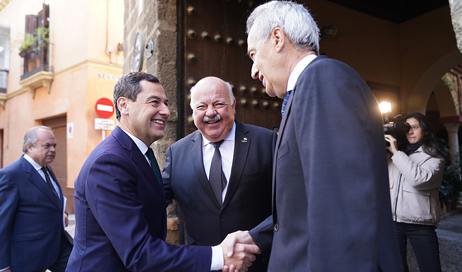 Juanma Moreno saluda al presidente de la Real Academia Sevilla de Buenas Letras, Pablo Gutiérrez-Alviz Conradi, en presencia del presidente del Parlamento, Jesús Aguirre.
